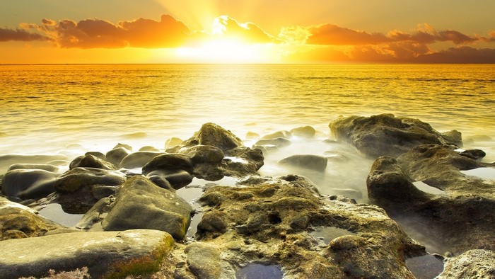 Sunset over the ocean with rocks