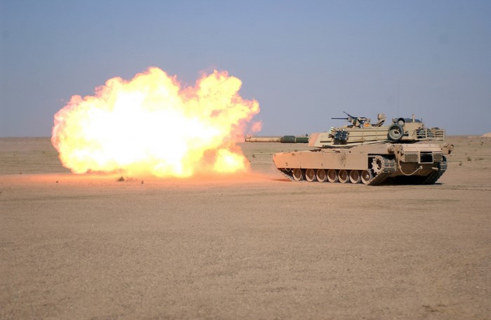 Tank firing a round in a desert