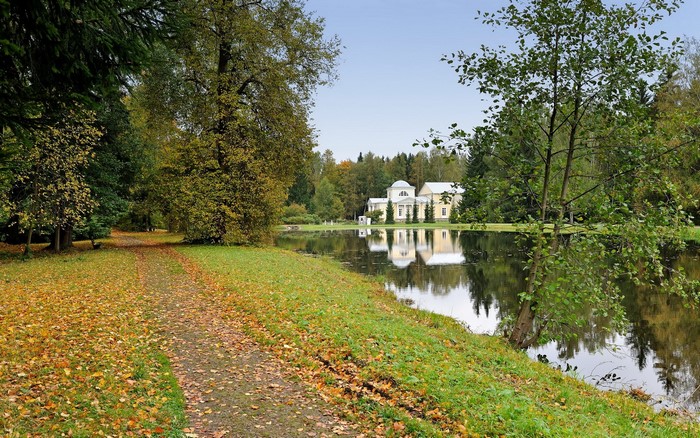 Park with a lake and a yellow building in Russia