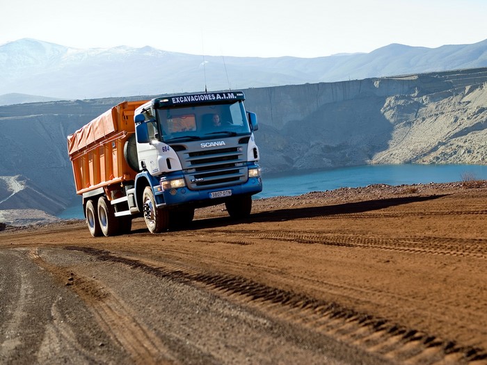 Scania dump truck driving on a dirt road