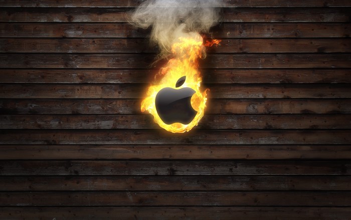 Apple logo on fire against wooden background