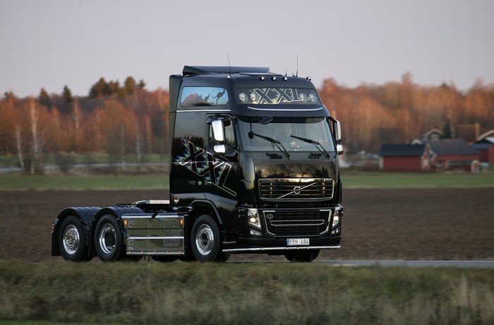 Black Volvo XXL truck driving on a road