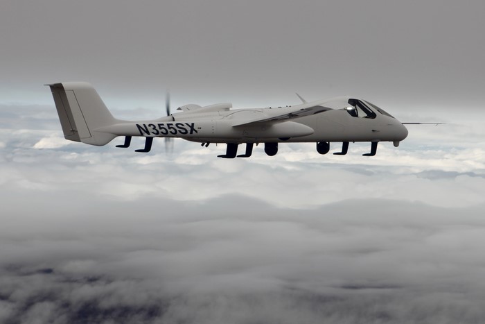 White twin-engine aircraft N355SX flying above clouds