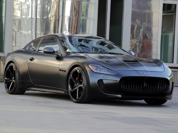 Matte black Maserati GranTurismo parked outside a modern building