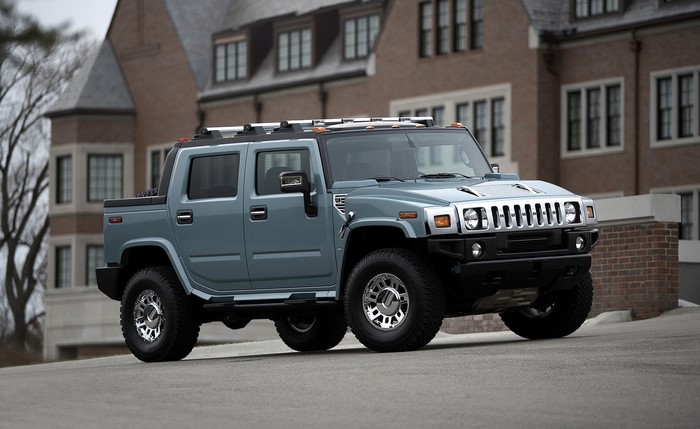 Blue Hummer H2 SUT parked in front of a brick building