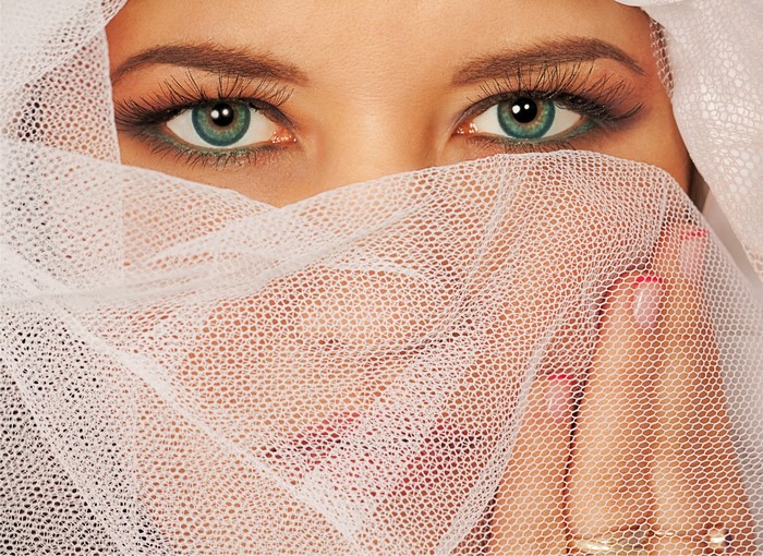 Woman's eyes covered by white fabric