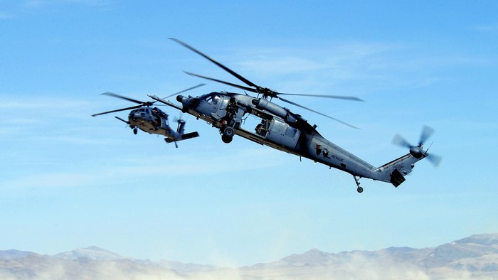 Two military helicopters flying in the sky