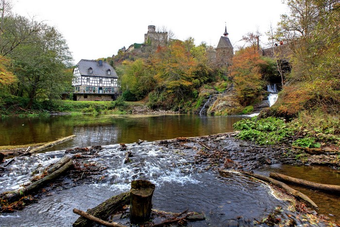 Half-timbered house and castle by a river in Germany