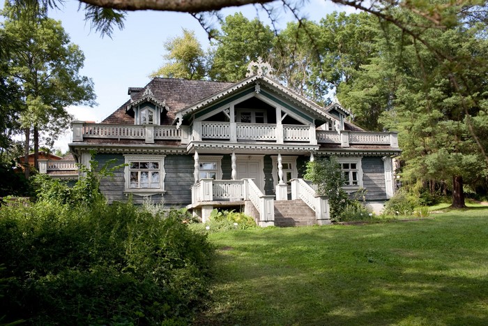 Wooden house with ornate details surrounded by trees