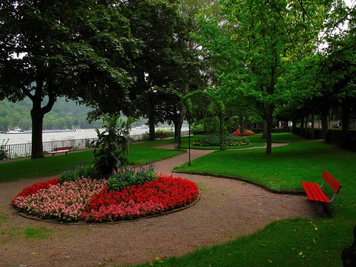 Park with flower beds and benches by a river