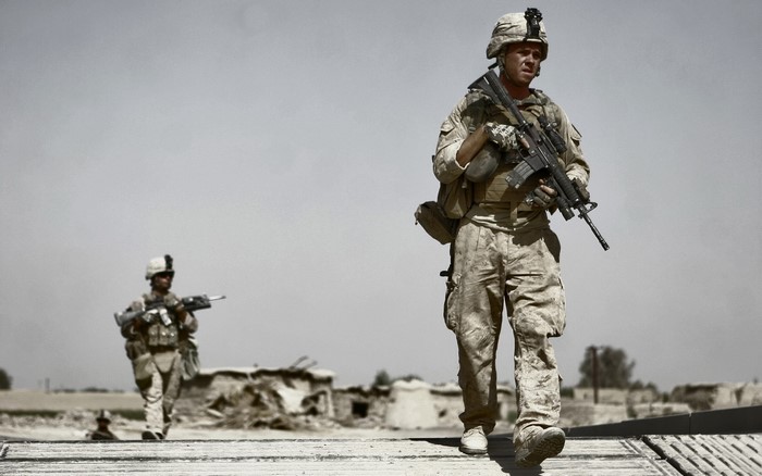 Two soldiers walking in a desert environment
