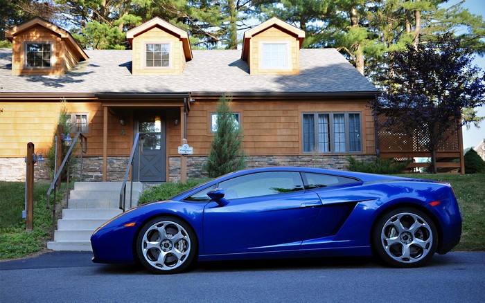 Blue Lamborghini parked in front of a house