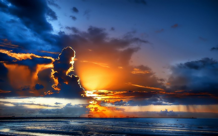 Dramatic sunset over the ocean with dark clouds