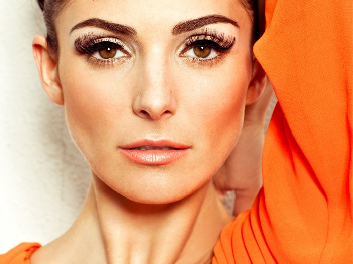 Woman with dramatic makeup and orange dress