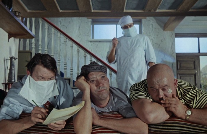 Three men in a room, one in medical attire