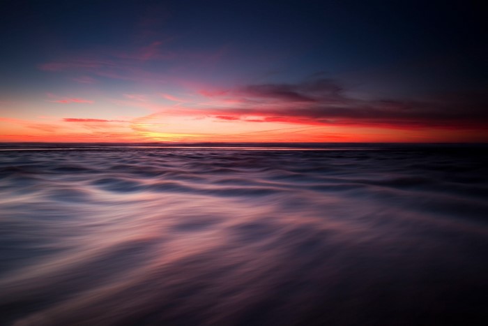 Ocean waves at sunset with colorful sky