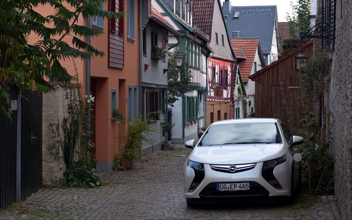 White Opel Ampera parked on cobblestone street