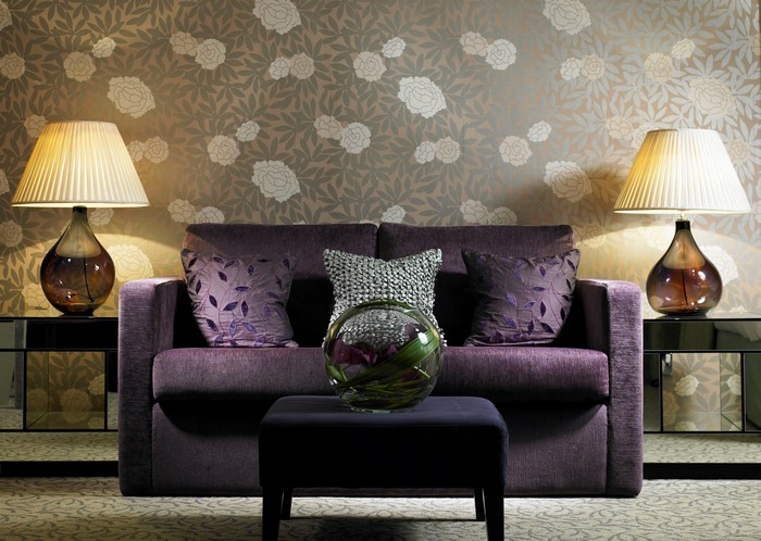 Purple sofa with lamps and floral wallpaper