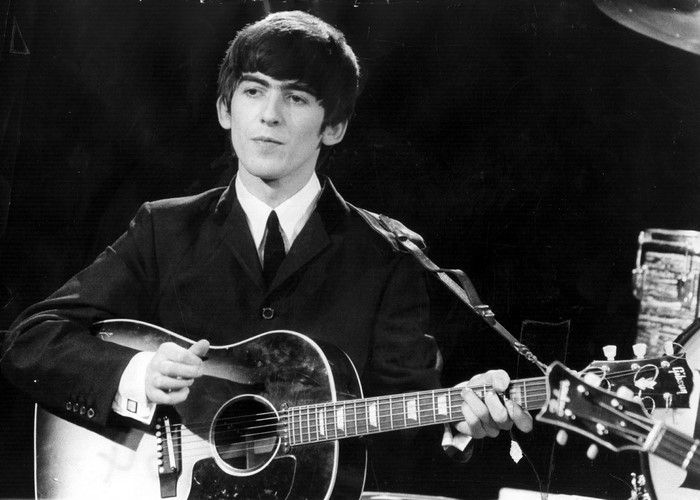George Harrison from The Beatles playing guitar