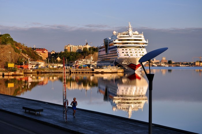 Cruise ship docked in Nacka, Sweden with a runner on the pier