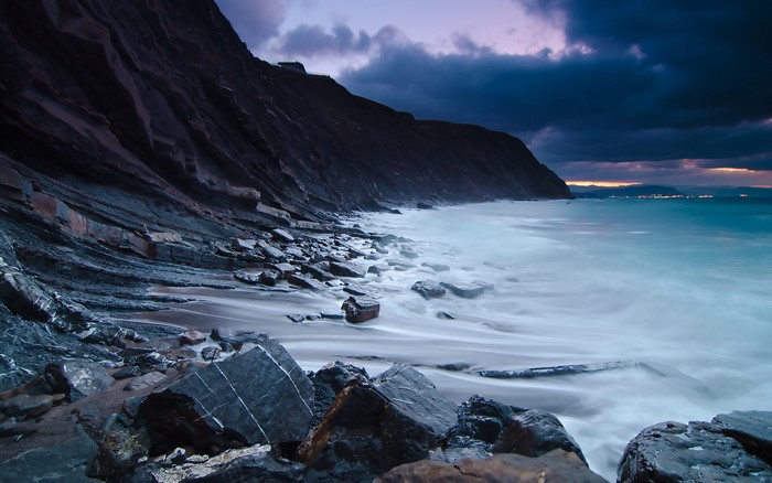 Rocky coastline with waves at dusk