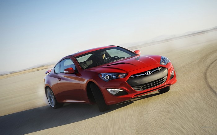 Red Hyundai Genesis Coupe driving on a dirt road