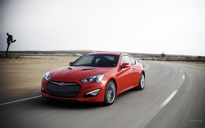 Red Hyundai Genesis Coupe driving on a desert road