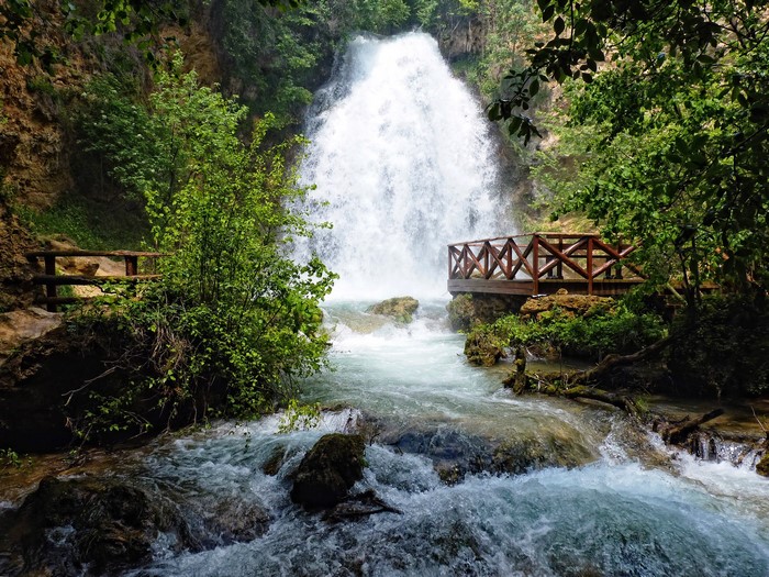 Waterfall with wooden viewing platforms and lush greenery