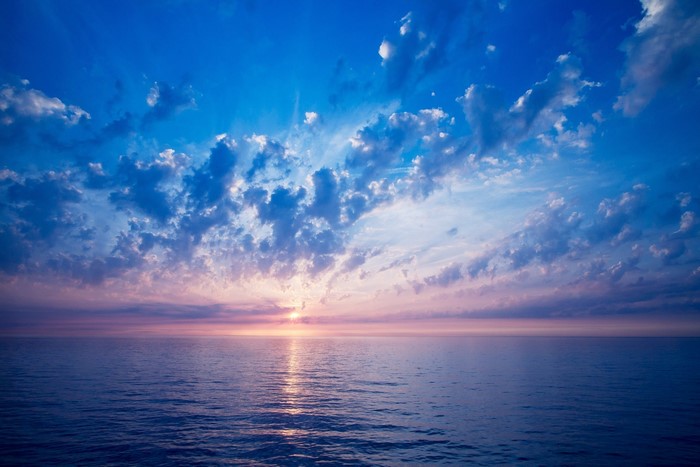 Sunset over the open sea with clouds