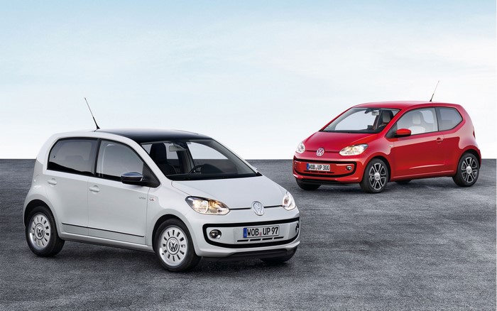 Two Volkswagen Up! cars on a gray surface