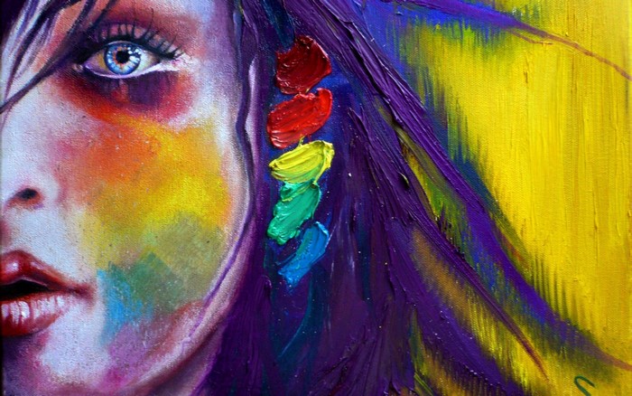 Close-up of a woman's face with rainbow paint