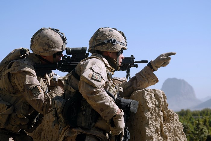 Two soldiers aiming weapons in a desert landscape