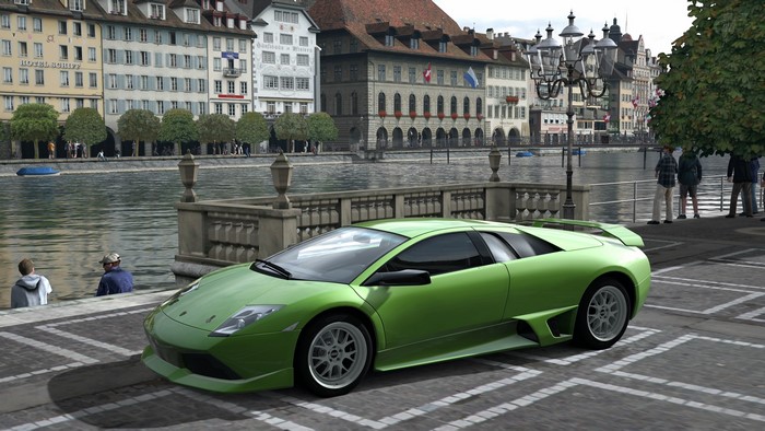 Green Lamborghini parked by a river in a European city
