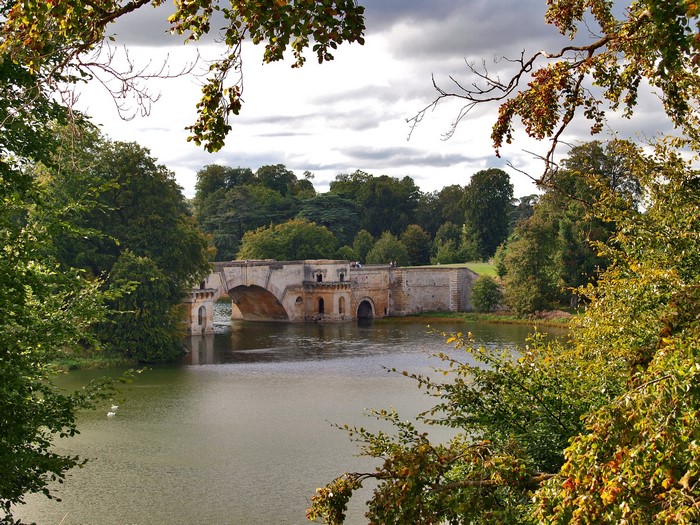 Stone bridge over a lake surrounded by trees