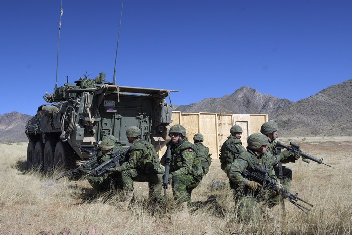 Soldiers with military vehicle in desert landscape