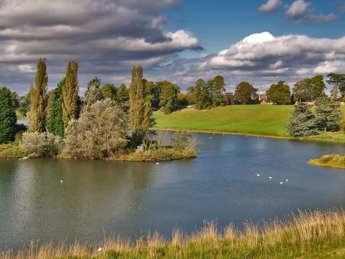 A lake with trees and a building in the background