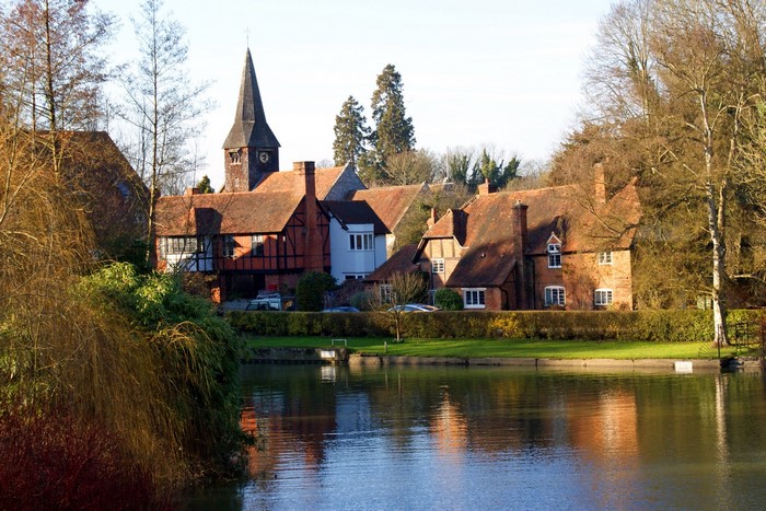 Houses and church by a river in the United Kingdom