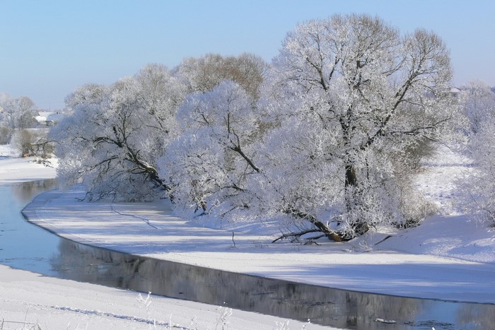 Winter scene with a river and snow-covered trees in Lithuania