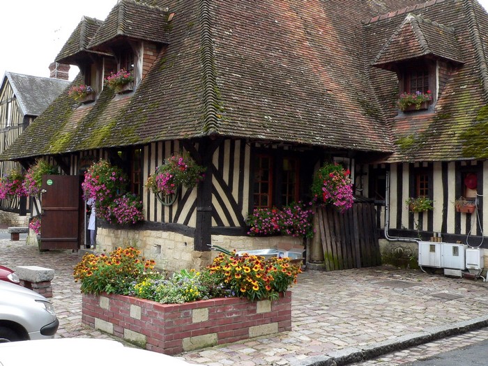 Half-timbered houses with flowers in Beuvron-en-Auge, Normandy, France