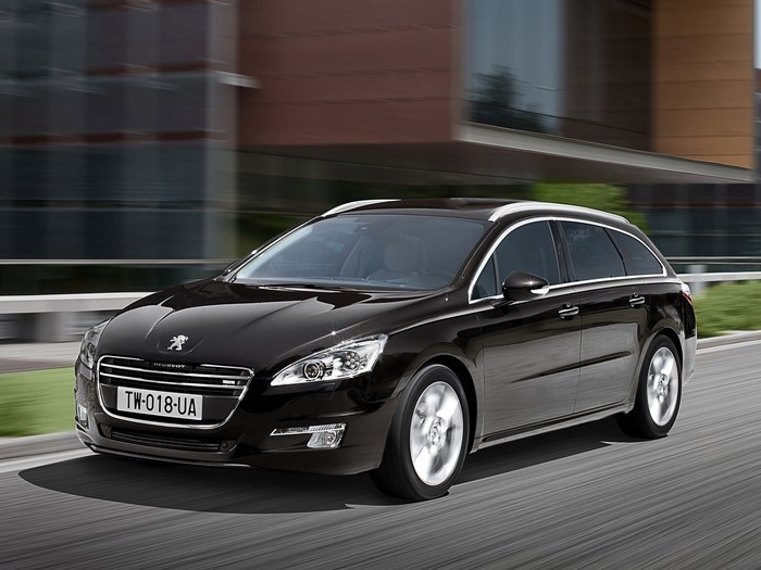 Black Peugeot 508 SW driving on a road