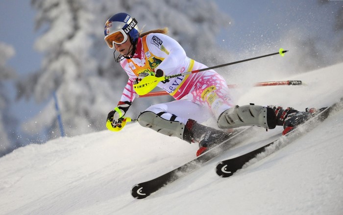 Female skier in white and pink racing suit