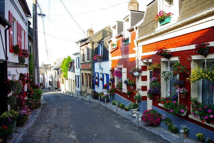 Street lined with colorful houses and flowers in France