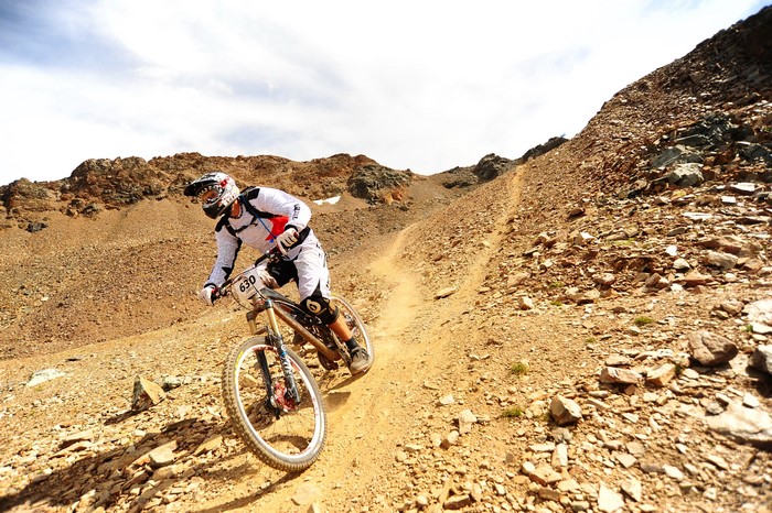Mountain biker racing downhill on a rocky slope