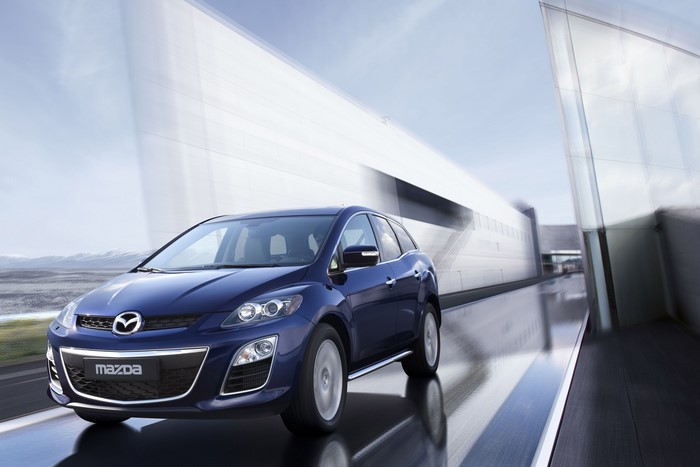 Blue Mazda CX-7 driving on a wet road