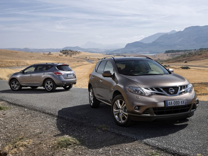 Two Nissan Murano SUVs on a road in a dry landscape