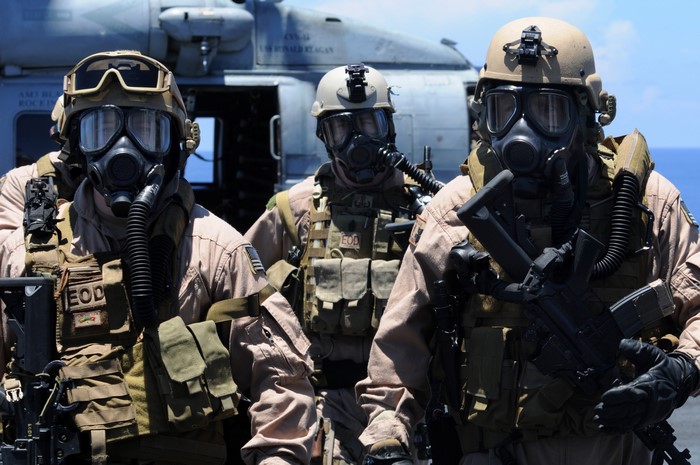 Three soldiers in gas masks and tactical gear