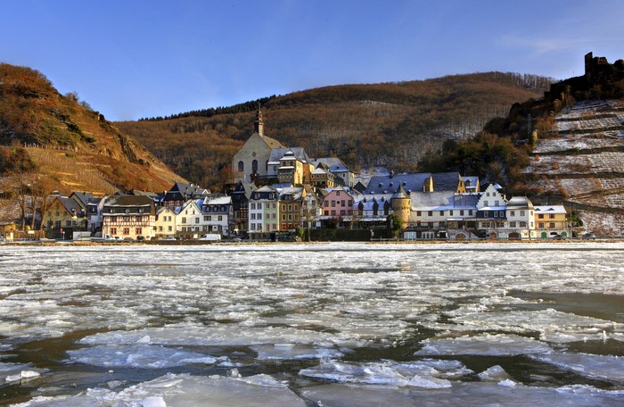 Frozen river in front of a German town with a church