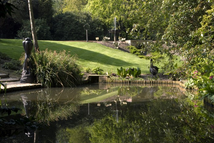 Park with pond, sculpture, and fountain