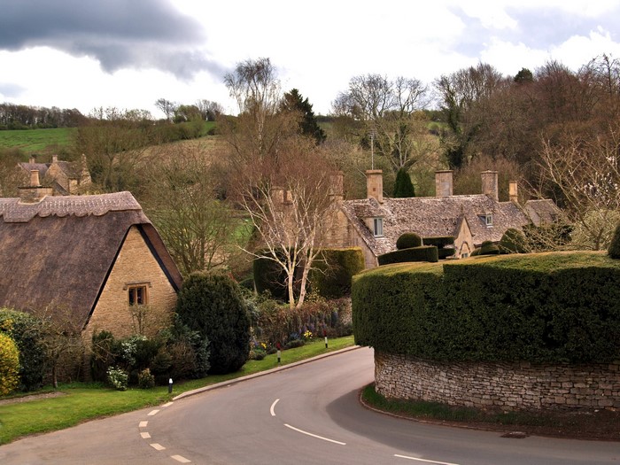 Thatched roof cottages on a winding road in the United Kingdom