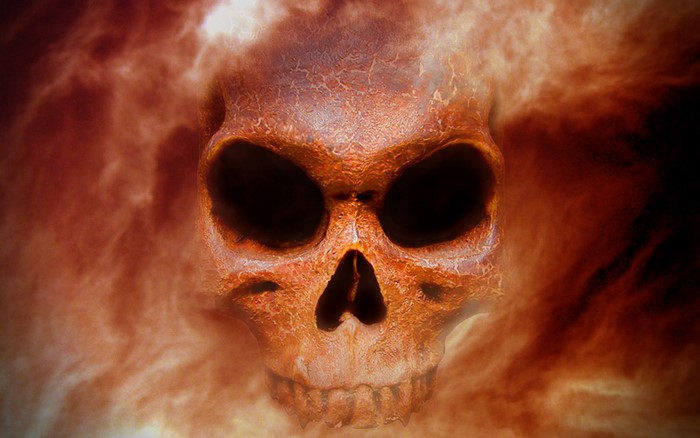 A fiery skull emerges from smoke